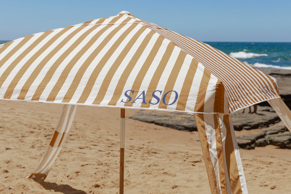 The Esperance Cabana with golden yellow and white striped canopy set up outdoors