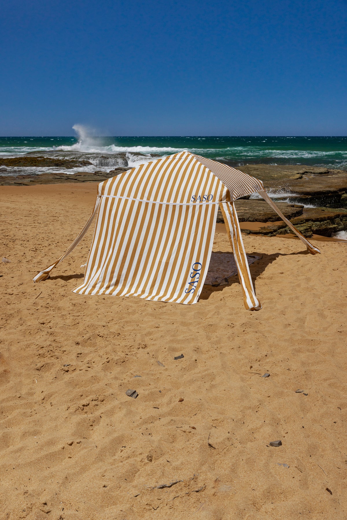 The Esperance Cabana with golden yellow and white striped canopy set up outdoors