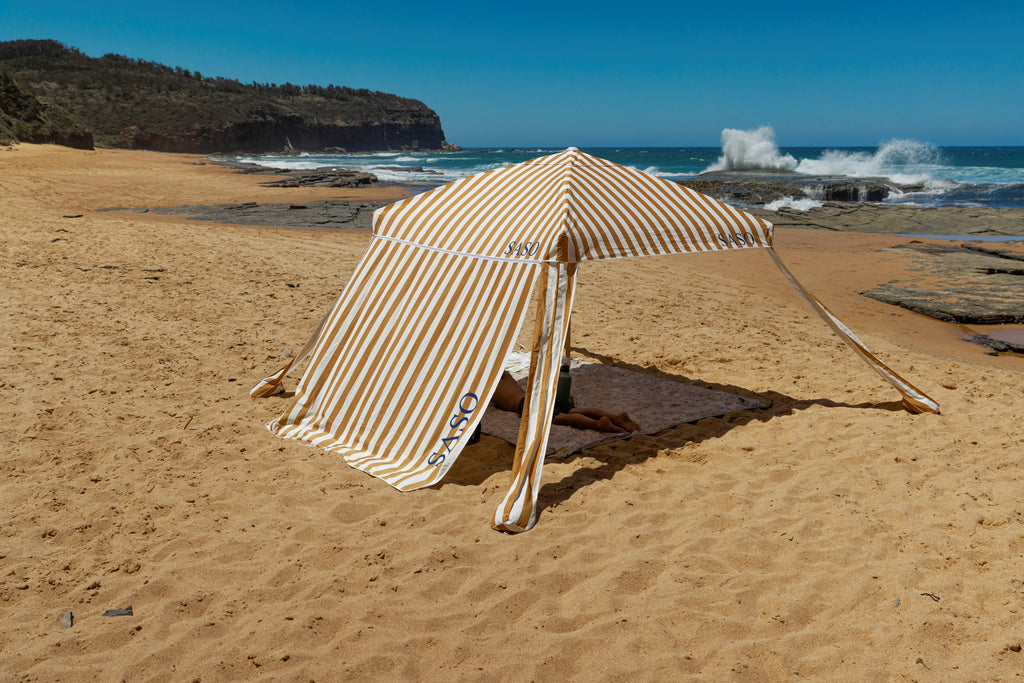 The Esperance Cabana with golden yellow and white striped canopy set up outdoors