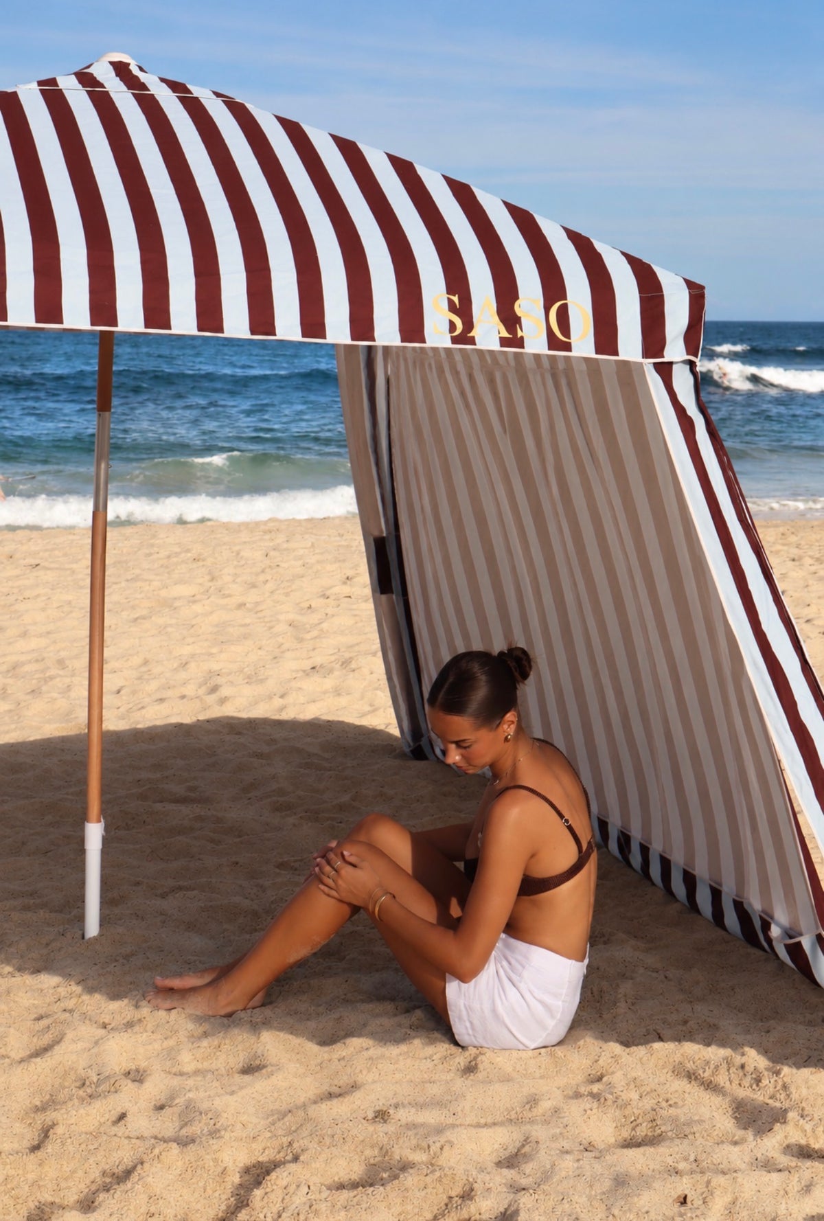 The Burleigh Cabana in brown-burgundy and pale sky blue stripes at the beach